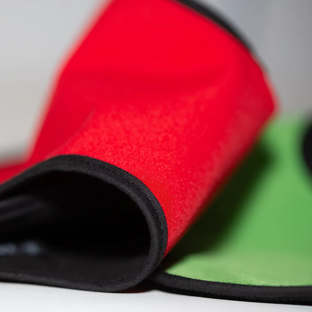 Closeup of red and green belly wraps showing the fabric and black edge binding